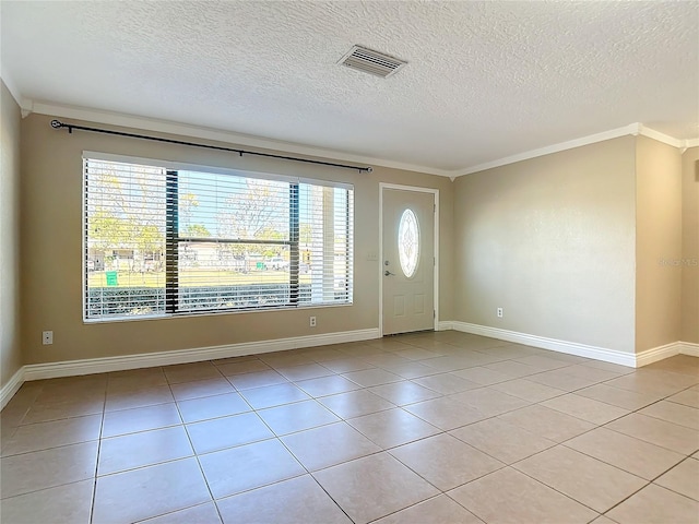 tiled foyer entrance with a textured ceiling, plenty of natural light, and crown molding