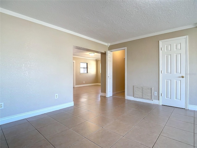 tiled spare room with crown molding and a textured ceiling