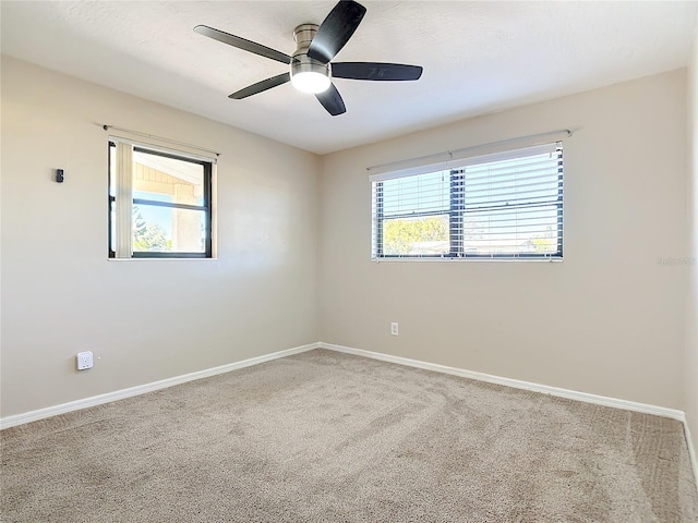 carpeted empty room featuring a wealth of natural light and ceiling fan