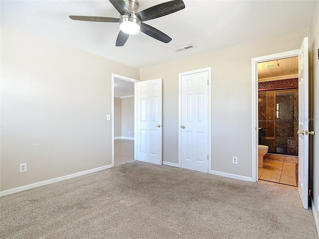 unfurnished bedroom with ceiling fan, a closet, light carpet, and ensuite bath