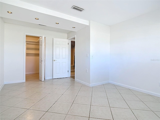 1037 Poinsetta St, Cocoa, FL 32927 - unfurnished bedroom with recessed lighting, light tile patterned floors, baseboards, and a walk in closet