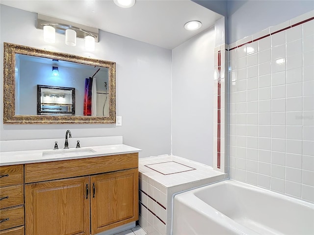 bathroom featuring tiled tub and vanity