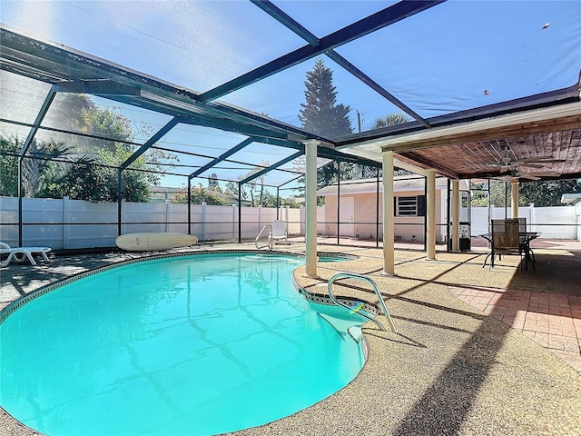 view of pool with glass enclosure, ceiling fan, and a patio