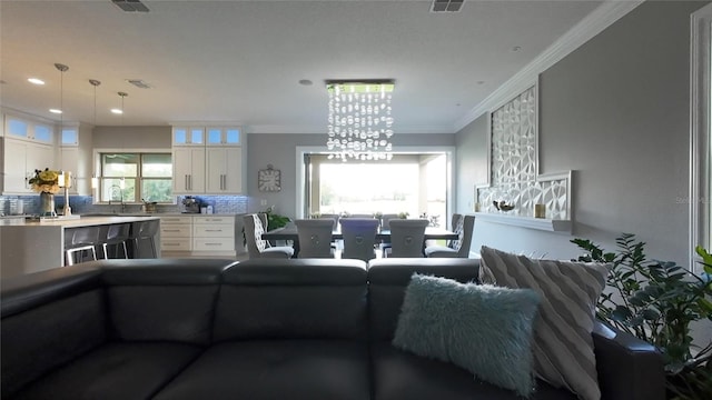 living room featuring crown molding and a chandelier