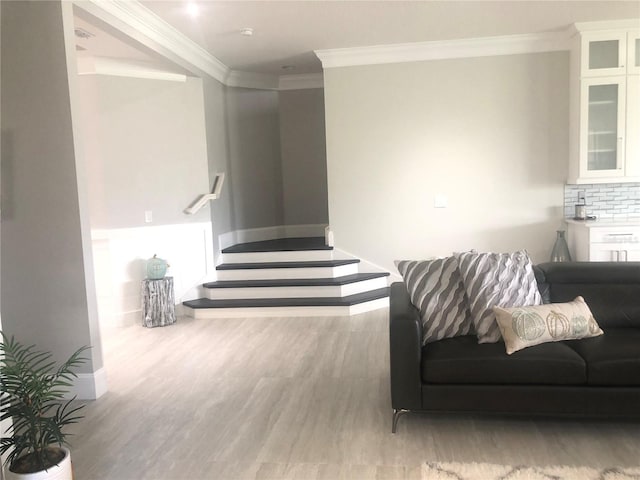 living room with crown molding and light hardwood / wood-style flooring