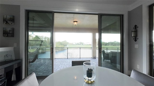 dining space featuring a water view and ornamental molding