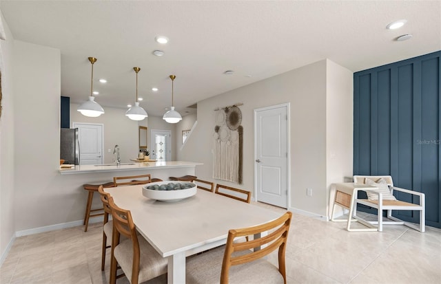 tiled dining space featuring a textured ceiling and sink