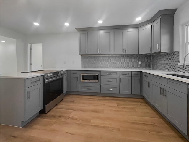 kitchen featuring gray cabinets, appliances with stainless steel finishes, and light hardwood / wood-style flooring