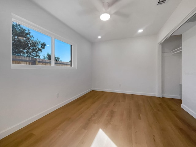 unfurnished bedroom featuring ceiling fan, a closet, and hardwood / wood-style flooring