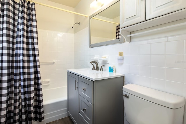 bathroom with tile walls, tasteful backsplash, shower / bathtub combination with curtain, toilet, and vanity