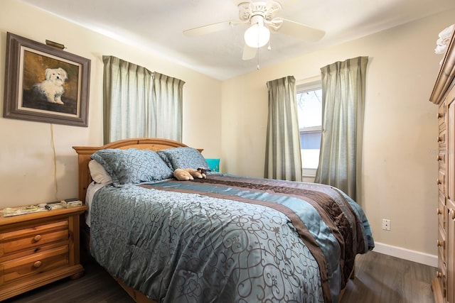 bedroom with dark wood-style flooring, a ceiling fan, and baseboards