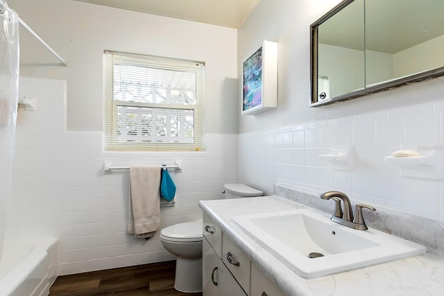 bathroom featuring shower / tub combo, wainscoting, toilet, wood finished floors, and vanity