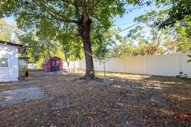 view of yard with a shed, an outdoor structure, and a fenced backyard