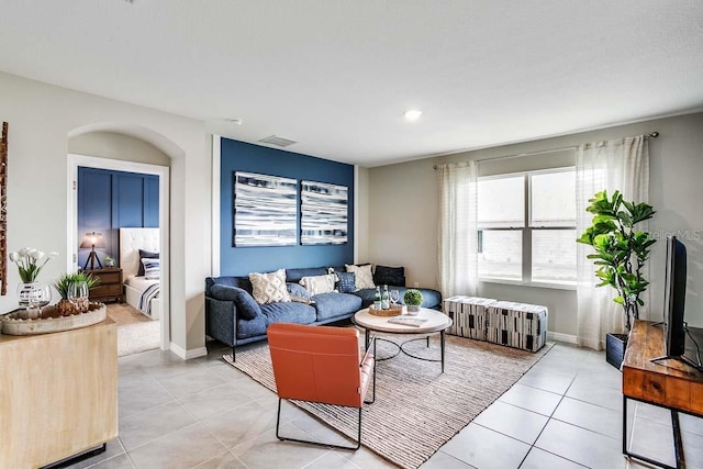 living room featuring radiator and light tile patterned flooring