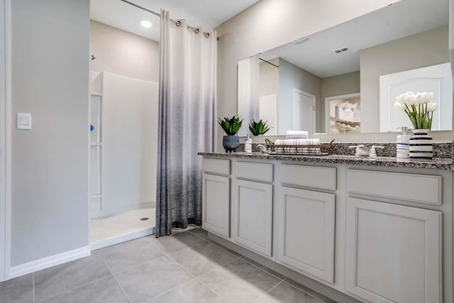 bathroom featuring vanity, tile patterned floors, and walk in shower