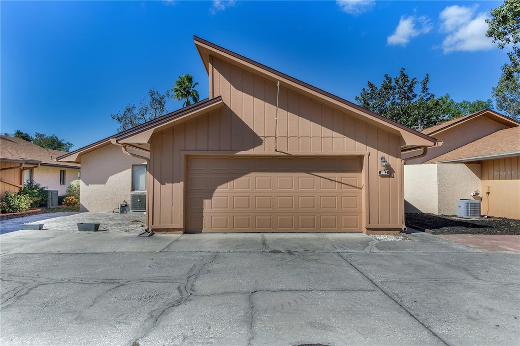 ranch-style home with a garage and central air condition unit