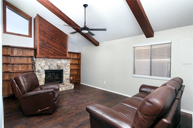 living room with dark wood-type flooring, a stone fireplace, vaulted ceiling with beams, ceiling fan, and a textured ceiling