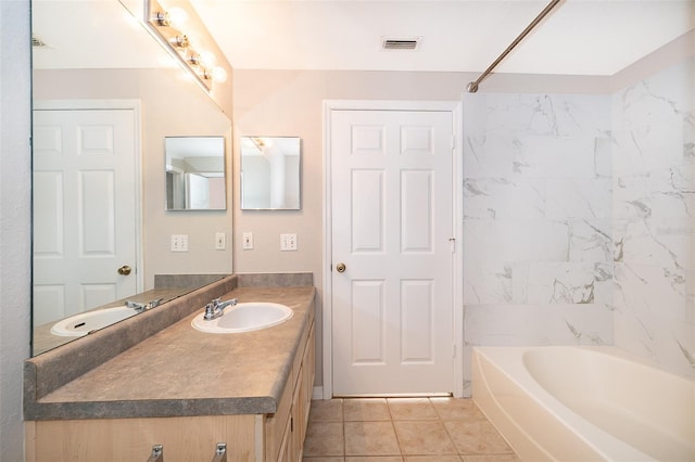 bathroom featuring tile patterned flooring, vanity, and tiled shower / bath combo