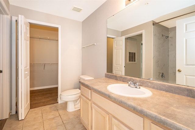 bathroom featuring a shower, vanity, tile patterned floors, and toilet