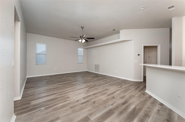 unfurnished living room featuring ceiling fan, a textured ceiling, and hardwood / wood-style flooring