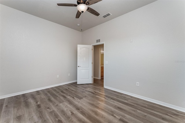 unfurnished room with ceiling fan, hardwood / wood-style floors, and a high ceiling