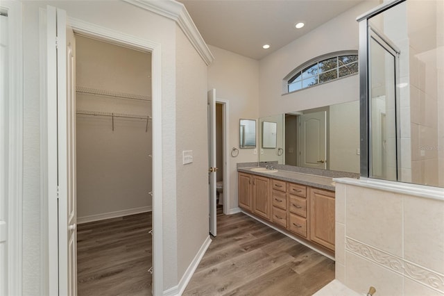 bathroom featuring vanity, hardwood / wood-style flooring, toilet, and walk in shower