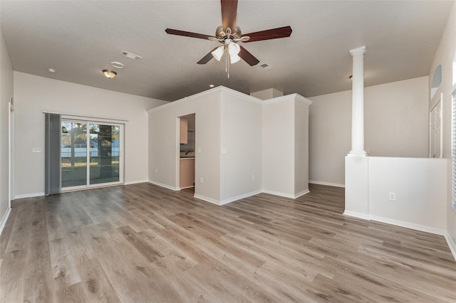 unfurnished living room featuring decorative columns, ceiling fan, and light hardwood / wood-style floors