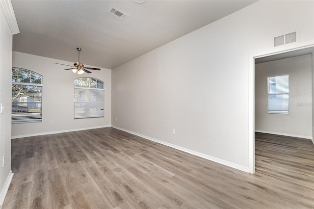 unfurnished room with light wood-type flooring, ceiling fan, and lofted ceiling