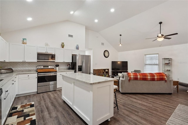 kitchen featuring decorative backsplash, stainless steel appliances, and white cabinets