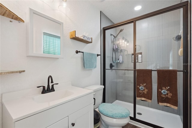 bathroom with an enclosed shower, vanity, and toilet