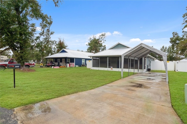 exterior space featuring a sunroom, a yard, and a carport