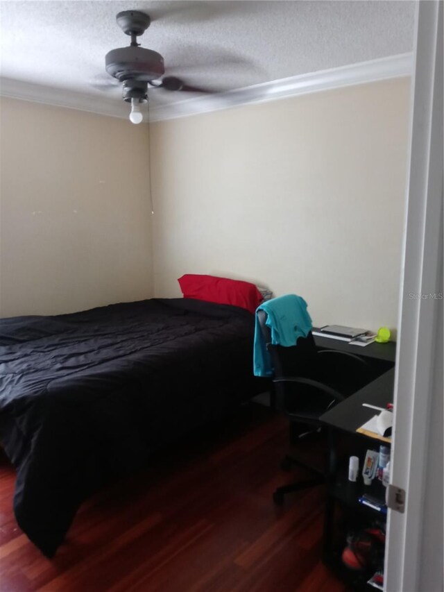 bedroom with a textured ceiling, crown molding, a ceiling fan, and wood finished floors