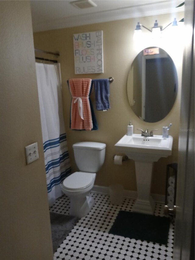 full bathroom with curtained shower, baseboards, toilet, and crown molding