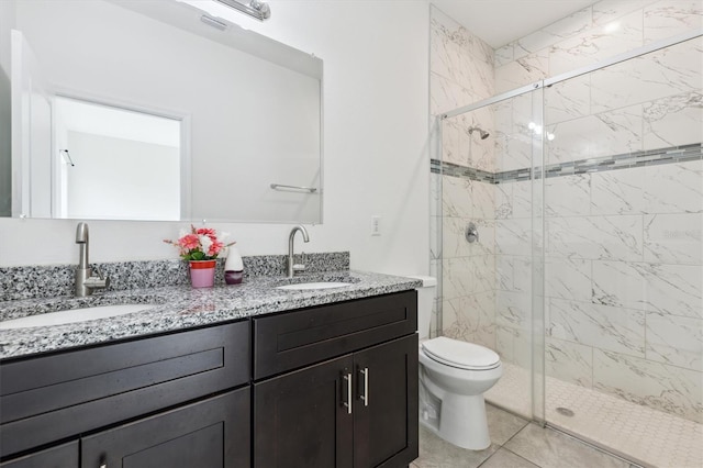 bathroom with tile patterned flooring, vanity, toilet, and walk in shower