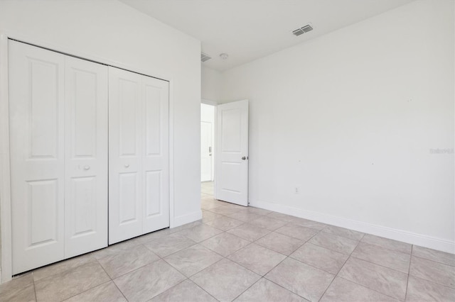 unfurnished bedroom with a closet and light tile patterned floors