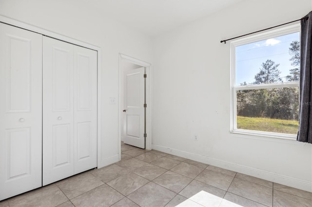 unfurnished bedroom with a closet and light tile patterned floors