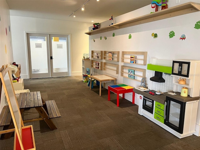 playroom featuring track lighting and dark carpet