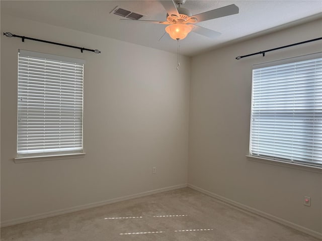 empty room featuring ceiling fan and light carpet