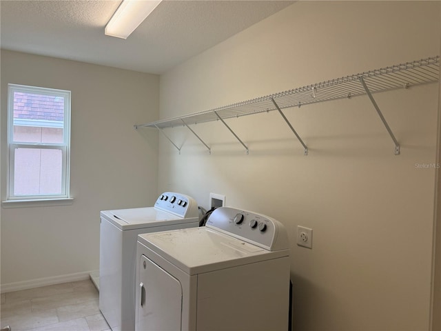 washroom with washer and dryer and a textured ceiling