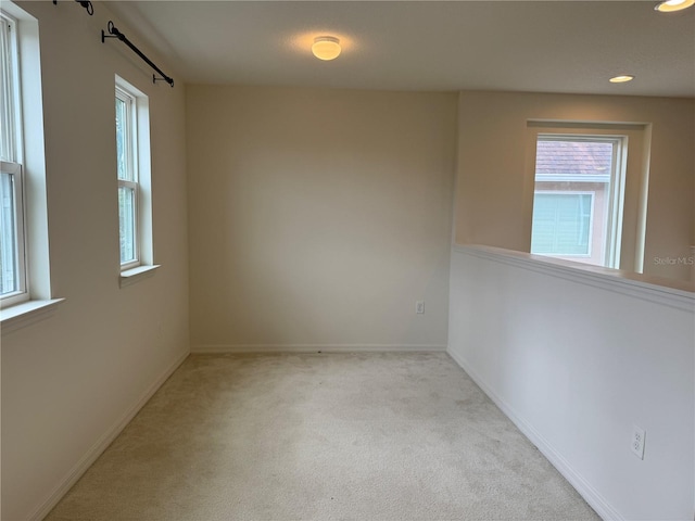 spare room featuring light colored carpet