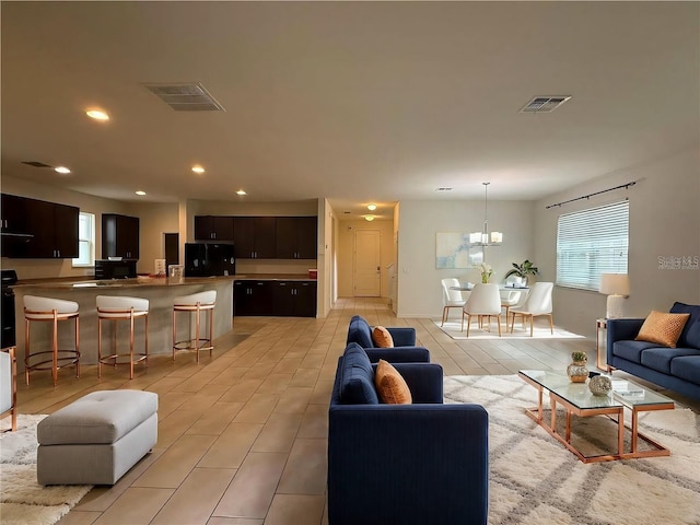 living room featuring light tile patterned flooring and a notable chandelier