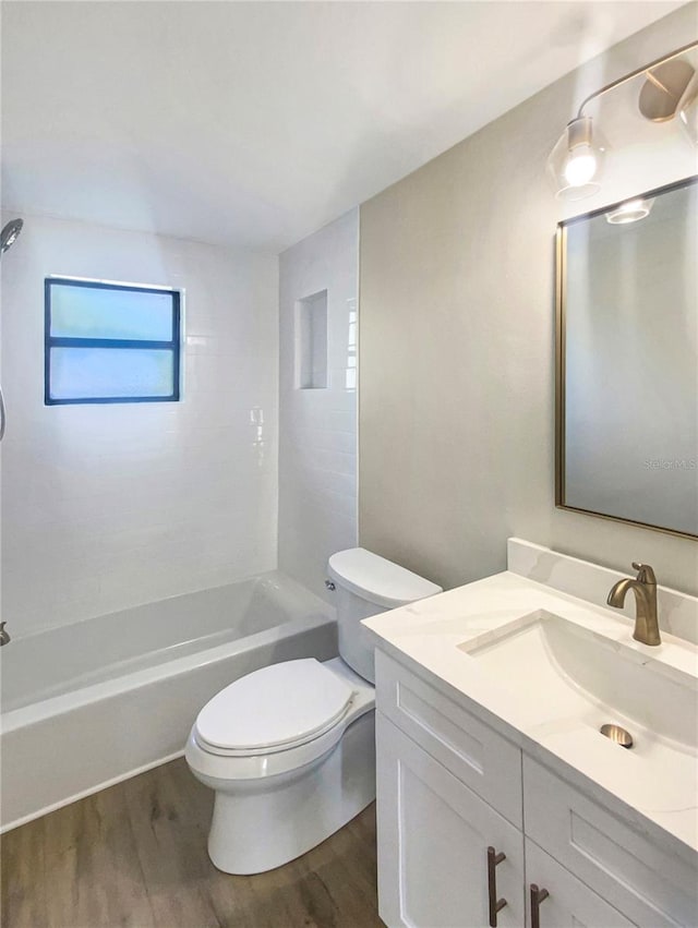 full bathroom with wood-type flooring, vanity, toilet, and tiled shower / bath combo