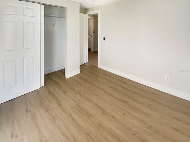 unfurnished bedroom featuring light hardwood / wood-style floors and a closet