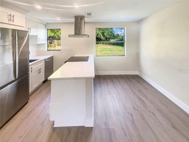 kitchen featuring a wealth of natural light, white cabinets, extractor fan, and appliances with stainless steel finishes