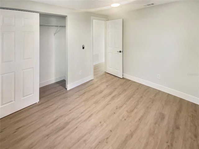 unfurnished bedroom featuring a closet and light wood-type flooring