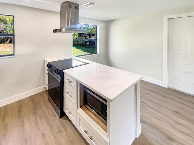 kitchen with white cabinets, island range hood, electric range, and light hardwood / wood-style floors