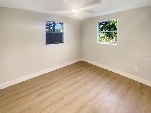 unfurnished room with hardwood / wood-style flooring, ceiling fan, and a healthy amount of sunlight