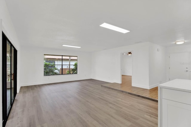 unfurnished living room featuring light hardwood / wood-style floors and ceiling fan