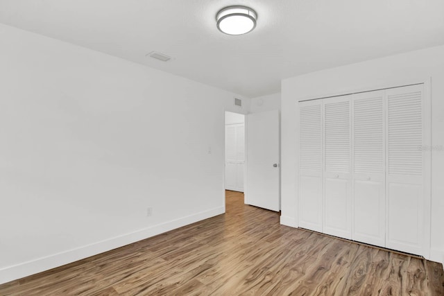 unfurnished bedroom with a closet and light hardwood / wood-style flooring