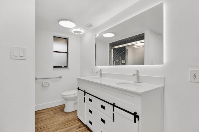 bathroom with vanity, wood-type flooring, a shower with shower door, and toilet